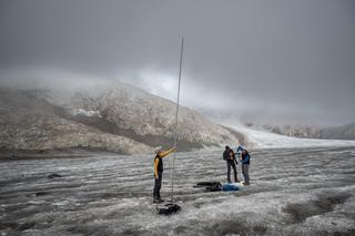 Le glaciologue Matthias Huss tient une lance de 6,5 mètres de haut qui symbolise la hauteur de la glace fondue sur le glacier, au dessus de Ulrichen (Suisse), le 2 septembre 2022.