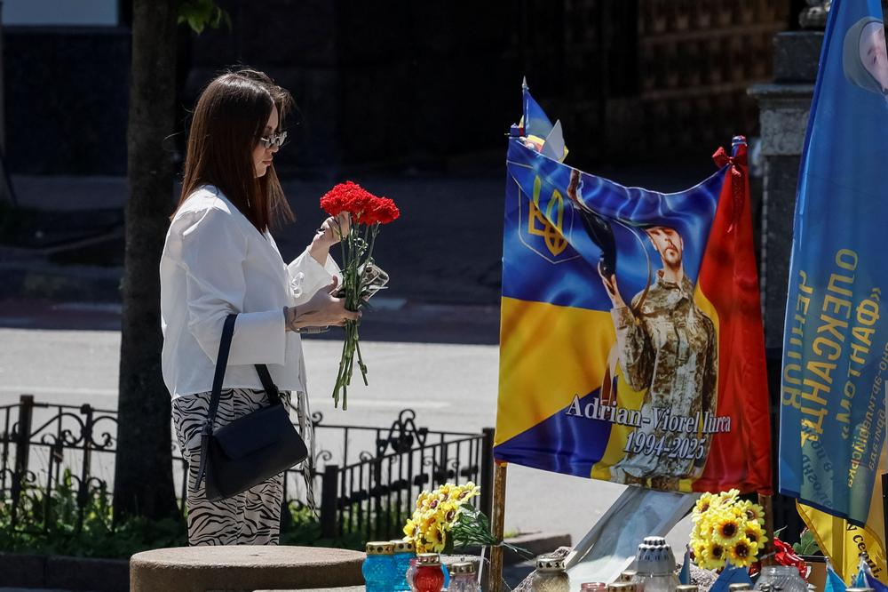 Une femme devant un mémorial improvisé dédié aux militaires ukrainiens tombés pendant la guerre combat, à Kiev, le 23 mai 2026. - GLEB GARANICH / REUTERS