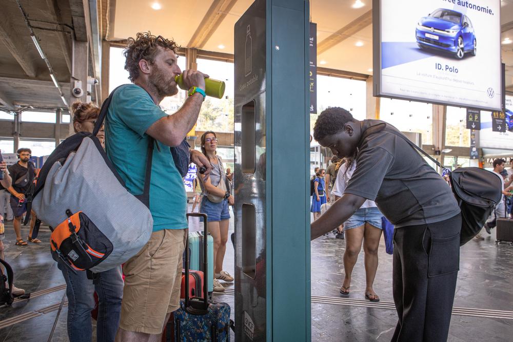 Des voyageurs remplissent des bouteilles d'eau à une fontaine mise à disposition par la SNCF, à Nantes, le 25 mai 2026. - JÉRÉMIE LUSSEAU/HANS LUCAS POUR « LE MONDE »