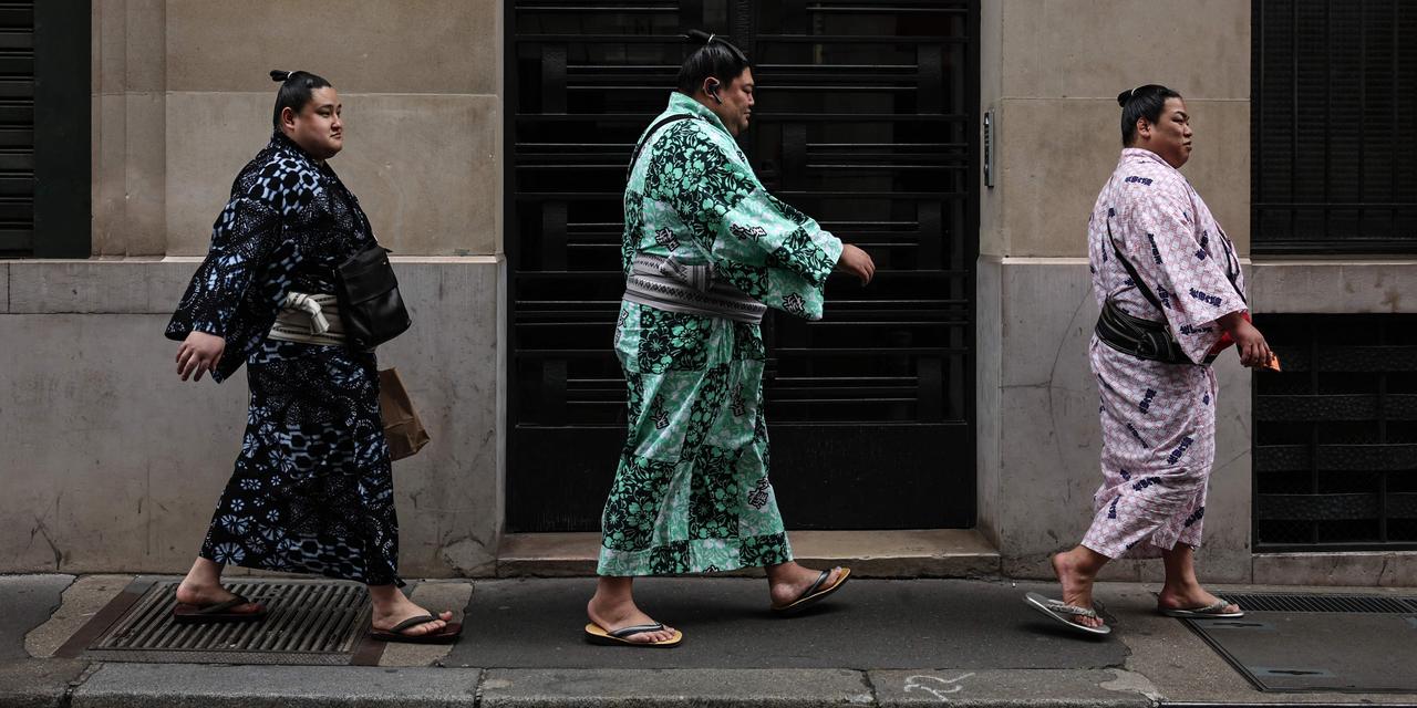 Sumo wrestlers walk in a street of Paris on June 11, 2026.  Paris is holding on June 13 and 14, 2026 the Paris Sumo Tournament.  (Photo by SIMON WOHLFAHRT / AFP)