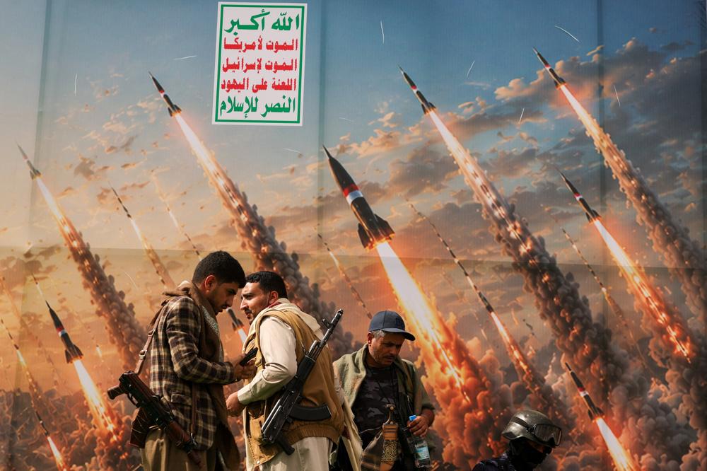 Des houthistes devant une affiche mettant en scène des missiles lancés par ces rebelles du Yémen, à Sanaa, le 31 juillet 2026. - KHALED ABDULLAH / REUTERS