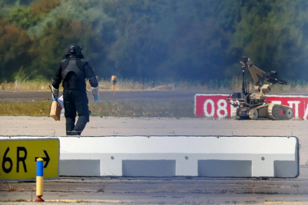 Un technicien de la police scientifique et un robot de déminage, suite à la découverte d’un drone chargé d’explosifs à l’aéroport de Leipzig-Halle, à Schkeuditz (Allemagne), le 5 août 2026. - AXEL SCHMIDT/REUTERS