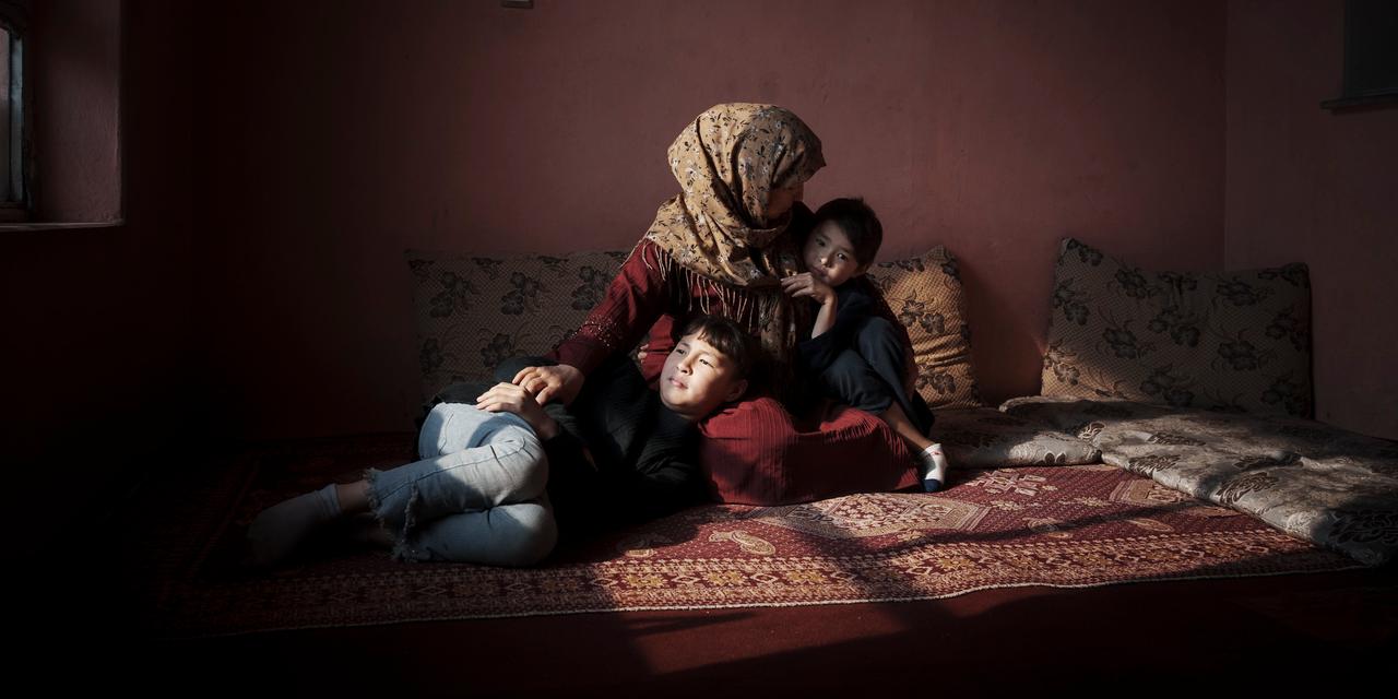KABOUL, AFGHANISTAN. 21/01/2025. Mina tient ses deux plus jeunes enfants dans son salon. Sa fille vient de terminer sa 6ème classe, le dernier niveau autorisé pour les filles, et ne fera pas sa rentrée dans quelques semaines. Mina est institutrice – il est encore permis aux femmes d’enseigner aux toutes petites sections. Mina a connu le premier règne taliban, il est d’autant plus douloureux pour elle de voir l’histoire se répéter et sa fille vivre les mêmes choses qu’elle.