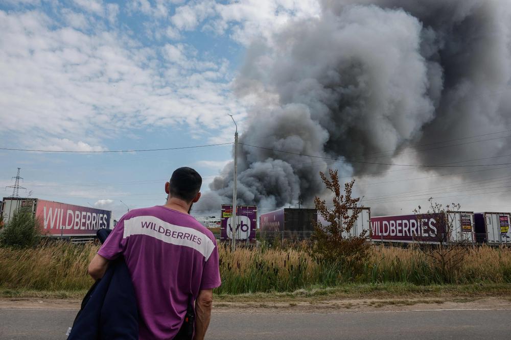 Un employé de Wildberries devant le centre de logistique en feu après une attaque aérienne ukrainienne, près de la ville de Podolsk, en périphérie de Moscou, le 16 août 2026. - TATYANA MAKEYEVA/AFP