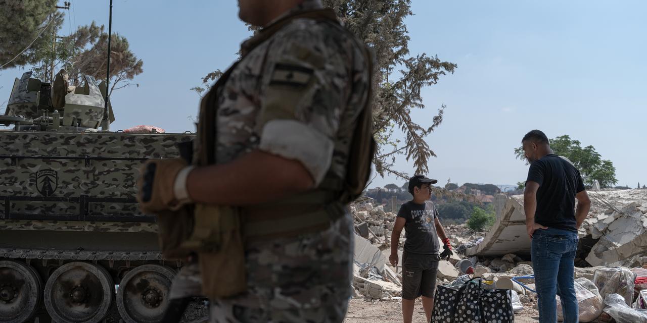 Abbas Mostafa, 37, stands with his son Ali, 10, beside belongings they salvaged from the rubble of their house, which was destroyed in an Israeli strike, in Zawtar al-Gharbiyeh, Nabatieh, southern Lebanon, August 28, 2026. Ali Khara for Le Monde