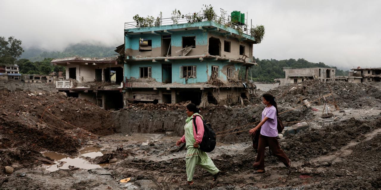 People walk past damaged houses following deadly flash floods and a mudslide, in Devighat, Nuwakot district, Nepal, September 21, 2026. REUTERS/Navesh Chitrakar TPX IMAGES OF THE DAY