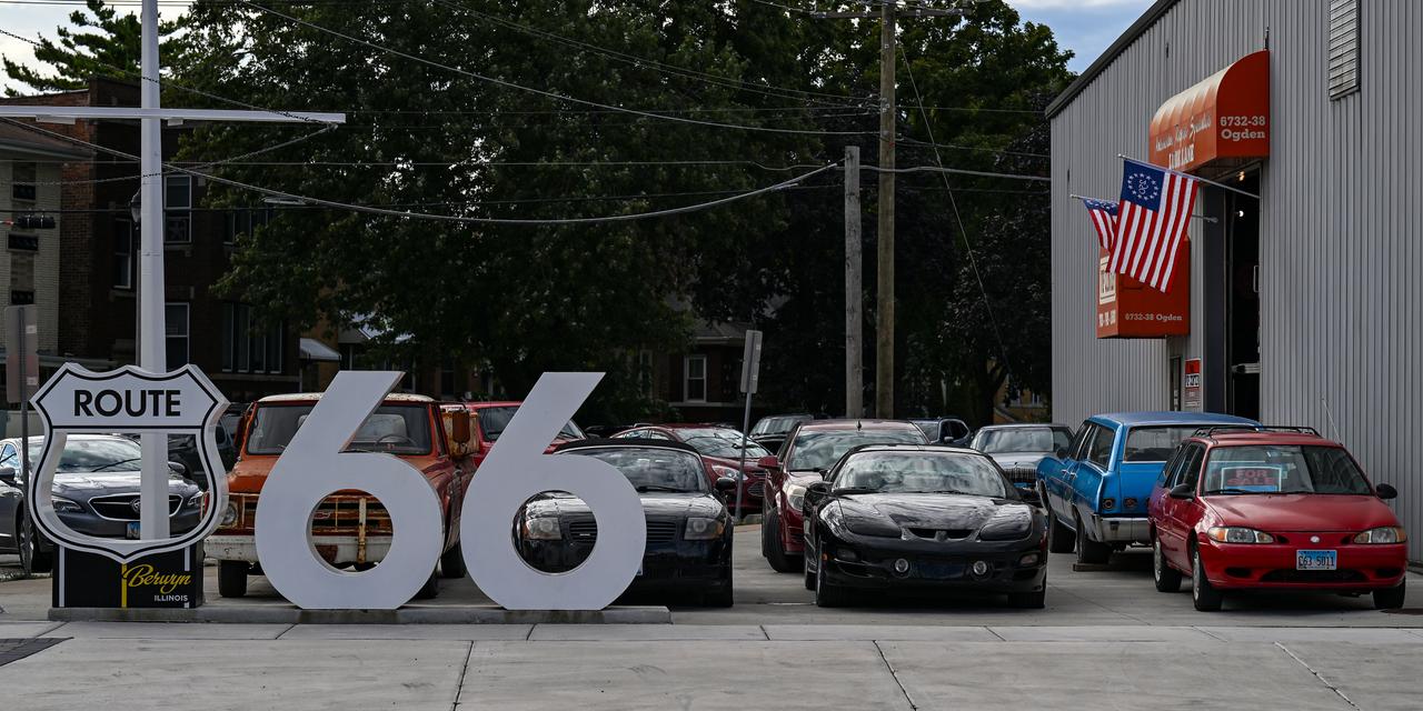 A used car dealer ship with vintage and classic vehicles sits along the former Route U.S. 66 highway on September 21, 2026 in Berwyn, Illinois. The former Route U.S. 66 road spans 2,448 miles from Chicago, Illinois to Santa Monica, California.  (Joshua Lott for Le Monde)