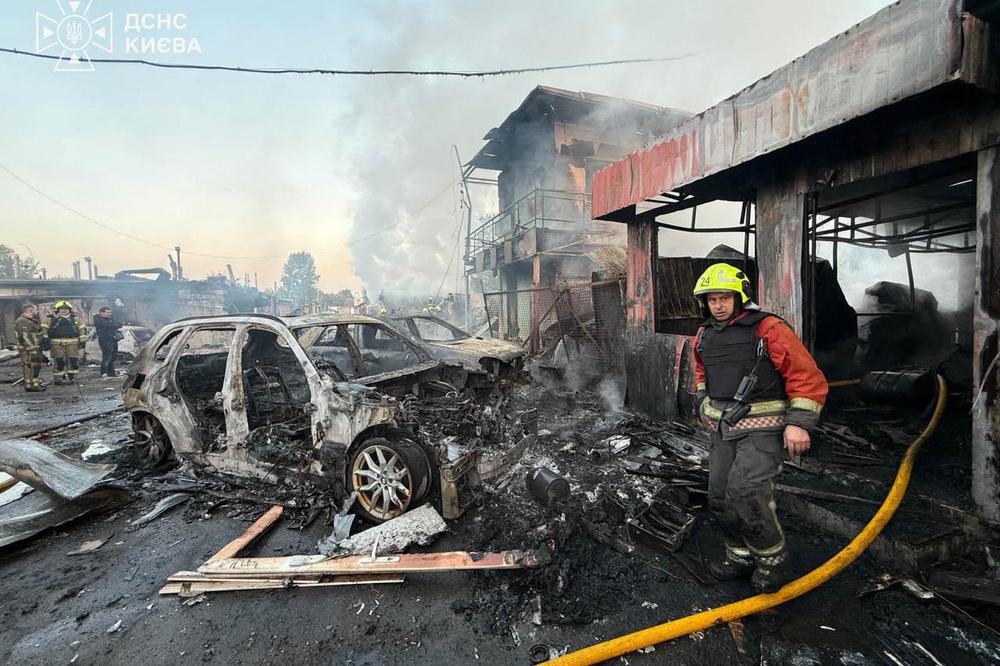 Des secouristes à l’œuvre parmi des voitures calcinées et des bâtiments endommagés à Kiev, à la suite d’une frappe de missile russe, le 7 octobre 2026 - SERVICE  D’URGENCE UKRAINIEN VIA AFP