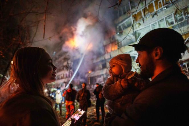 Victoria Deineko, son mari, Ievhen Deineko, et leur fille Mia devant un immeuble résidentiel endommagé par une frappe de missile russe à Kiev, le  13 octobre 2026.  - EVGENIY MALOLETKA/AP PHOTO/EVGENIY MALOLETKA