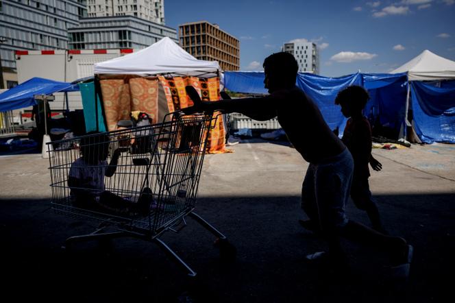 Des tentes de fortune occupées par des familles en attente d’un hébergement d’urgence, sur le parvis du siège du Samusocial, à Paris, le 1ᵉʳ août 2026. - SIMON WOHLFAHRT/AFP
