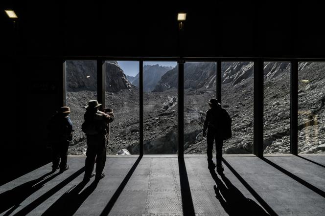 Des touristes observent la mer de Glace, un glacier en voie de disparition dans le massif du Mont-Blanc (Haute-Savoie), le 23 septembre 2026. - JEFF PACHOUD/AFP