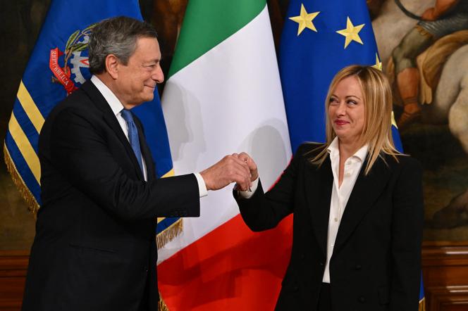 Mario Draghi, président du conseil italien sortant, donne une clochette à Giorgia Meloni, lors de la cérémonie de passation des pouvoirs à Rome, le 23 octobre 2022. - ANDREAS SOLARO/AFP