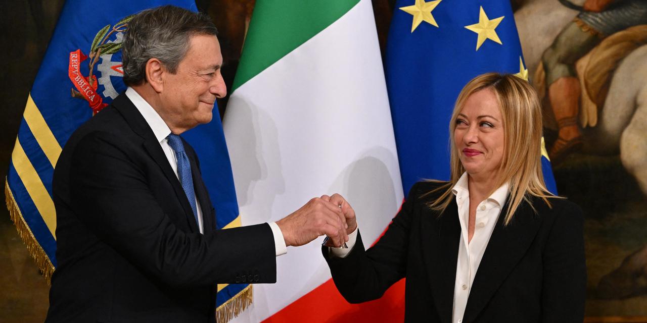 Italy's outgoing prime minister, Mario Draghi hands over the cabinet minister bell to Italy's new prime minister, Giorgia Meloni, during a handover ceremony at Palazzo Chigi in Rome on October 23, 2022. Far-right leader Giorgia Meloni was named Italian prime minister on October 21, 2022 after her party's historic election win, becoming the first woman to head a government in Italy. (Photo by Andreas SOLARO / AFP)