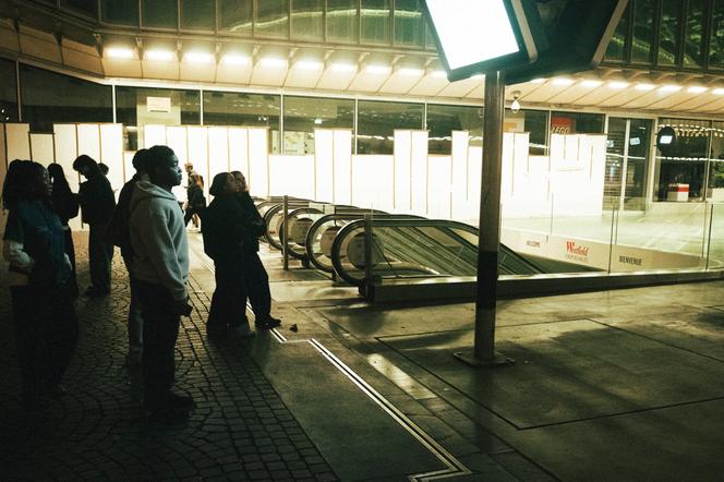 At the Forum des Halles in Paris, shortly before the start of a second night under curfew, passersby read an information board as the metro station is closed. - BENJAMIN CARROT FOR LE MONDE