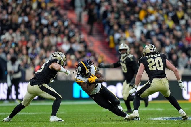 Pittsburgh Steelers running back Rico Dowdle is caught between New Orleans Saints linebacker Pete Werner and linebacker Kaden Elliss during the NFL game played in Saint-Denis, France, on October 25, 2026. - STEVE LUCIANO/AP PHOTO/STEVE LUCIANO