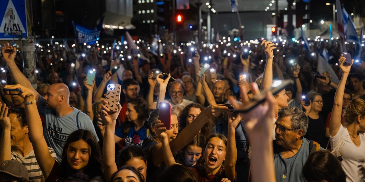 ISRAEL, Tel Aviv-Jaffa - Protestors raise their phones with flashlights on during a demonstration organised by the October Council, which represents more than 1,500 families and survivors and campaigns for a state commission of inquiry, on Hostage Square in central Tel Aviv on Saturday, October 24, 2026. Accountability for the attacks of October 7, 2023, is a central issue in Israel’s general election on October 27, 2026. Hostage families, bereaved relatives, survivors, residents of the south and families of soldiers killed in the later fighting have organised in groups such as the October Council, which represents more than 1,500 families and survivors and campaigns for a state commission of inquiry. While support for opposition parties has increased among many due to government dissatisfaction, some affected communities, especially in conservative southern areas, remain aligned with the ruling coalition. (Jonas Opperskalski)
