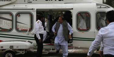 Nawaz Sharif (C), leader of political party Pakistan Muslim League-Nawaz (PML-N), disembarks from his helicopter as he arrives to address an election campaign rally in Peshawar May 7, 2013. Pakistan's general elections will be held on May 11. REUTERS/Fayaz Aziz (PAKISTAN - Tags: TRANSPORT POLITICS ELECTIONS)