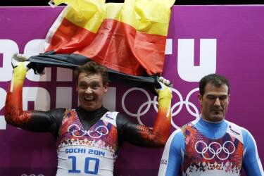 Felix Loch of Germany celebrates his gold medal win ,as bronze medalist Armin Zoeggeler of Italy stands next to him after the men's singles luge final at the 2014 Winter Olympics, Sunday, Feb. 9, 2014, in Krasnaya Polyana, Russia. (AP Photo/Natacha Pisarenko)