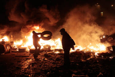 Anti-government protesters clash with riot police in Kiev's Independence Square, the epicenter of the country's current unrest, Kiev, Ukraine, Tuesday, Feb. 18, 2014. Thousands of police armed with stun grenades and water cannons attacked the large opposition camp in Ukraine's capital that has been the center of nearly three months of anti-government protests on Tuesday, after at least nine people were killed in street clashes.  (AP Photo/Sergei Chuzavkov)
