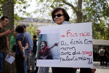 A Pro-Palestinian demonstrator holds a banner reading "France, you write your name with Palestinian blood", on the Republique square in Paris, ahead of a banned demonstration against Israel's military operation in Gaza and in support of the Palestinian people, on July 26, 2014. French authorities banned on July 26, 2014 a new pro-Palestinian demonstration over concerns it could turn violent as previous rallies have, but demonstrators may ignore the ban as they did last weekend. US Secretary of State John Kerry and other top diplomats from Europe and the Middle East began talks in Paris on July 26 to press efforts for a long-term ceasefire between Israel and Hamas. AFP PHOTO / KENZO TRIBOUILLARD