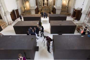 A general view of the Chinese artist Ai Weiwei six iron boxes part of a work presented as collateral event and shown during a press preview of the 55th edition of the Venice Biennale of Arts in Venice, northern Italy, Tuesday, May 28, 2013. The work on display is called S.A.C.R.E.D. The four initials standing for supper, accuser, cleansing, ritual, entropy and doubt, and referring to Ai Weiwei time 81 days in detention in 2011. Chinese artist Ai Weiwei has been prevented by Chinese authorities from traveling to Venice for the opening of two new works on the sidelines of the Biennale contemporary art show, so his mother came instead. Weiwei's elderly mother, Gao Yng, on Tuesday viewed for the first time a series of dioramas depicting six episodes of pressure during her son's 81 days in detention in 2011. (AP Photo/Domenico Stinellis)
