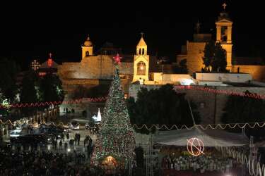 A view of Manger Square and the Church of the Nativity as people gather for Christmas eve celebrations in the biblical West Bank city of Bethlehem, believed to be the birthplace of Jesus Christ, on December 24, 2013. Thousands of Palestinians and tourists were flocking to Bethlehem to mark Christmas. AFP PHOTO/HAZEM BADER