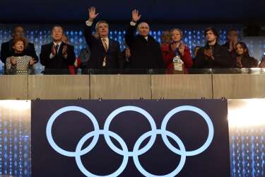 Russia's President Vladimir Putin C-R) and International Olympic Committee (IOC) President  Thomas Bach (C-L) wave during the Opening Ceremony of the Sochi Winter Olympics at the Fisht Olympic Stadium on February 7, 2014 in Sochi. AFP PHOTO / ALBERTO PIZZOLI