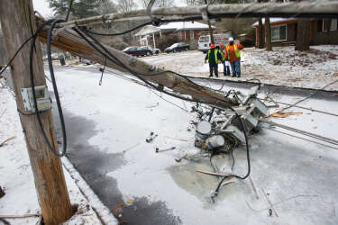 A crew asses the situation in front of a downed transformer smashed in the road during a winter storm on Wednesday, Feb. 12, 2014, in Doraville, Ga. About 175,000 customers were without power Wednesday afternoon, power companies reported.  (AP Photo/John Amis)