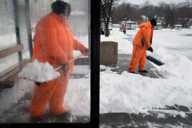 WASHINGTON, DC - FEBRUARY 13: Washington Metropolitan Area Transit Authority employees shovel snow out of bus stops at the Takoma Metrorail Station February 13, 2014 in Washington, DC. Up to 12 inches of snow fell over the Washington area causing WMATA to cancel bus service but rail service continued to operate.   Chip Somodevilla/Getty Images/AFP== FOR NEWSPAPERS, INTERNET, TELCOS & TELEVISION USE ONLY ==