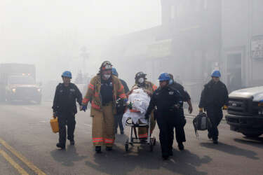 Rescue workers remove an injured person on a stretcher following a building explosion and collapse in East Harlem, Wednesday, March 12, 2014 in New York. (AP Photo/Mark Lennihan)