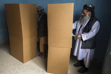 Afghan men vote at a polling station in Mazar-i-sharif  April 5,2014. Voting was largely peaceful in Afghanistan's presidential election on Saturday, with only isolated attacks on polling stations as a country racked by decades of chaos embarked on its first ever democratic transfer of power. REUTERS/Zohra Bensemra (AFGHANISTAN - Tags: POLITICS ELECTIONS)