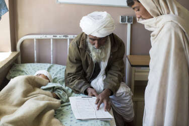 March 30, 2014 - Kandahar, Afghanistan - Mirwais Hospital sponsored by the Red Cross.The father of Noruhuda, a five-year-old boy wounded by shrapnel in a crossfire between Afghan National Army and Taliban insurgents, shows a relative bits of shrapnel from a mortar that wounded his son.