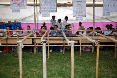Election officials wait for the polling officers to collect their Electronic Voting Machines (EVM) at a distribution centre ahead of general elections in Jorhat district, in the northeastern Indian state of Assam April 6, 2014. India, the world's largest democracy, will hold its general election in nine stages staggered between April 7 and May 12. REUTERS/Adnan Abidi (INDIA - Tags: POLITICS ELECTIONS)