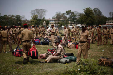 Policemen deployed on election duty wait for their name to be announced at a distribution centre ahead of general elections in Jorhat district, in the northeastern Indian state of Assam April 6, 2014. India, the world's largest democracy, will hold its general election in nine stages staggered between April 7 and May 12. REUTERS/Adnan Abidi (INDIA - Tags: POLITICS ELECTIONS)