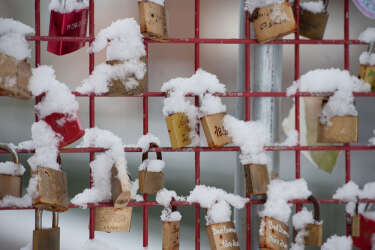Love locks fixed on a fence are covered in snow on December 13, 2012 in a park in Bad Bevensen, central Germany.      AFP PHOTO / PHILIPP SCHULZE    GERMANY OUT