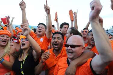 Soccer fans celebrate a goal scored by the Netherlands during a live broadcast of the World Cup match with Spain, inside the FIFA Fan Fest area on Copacabana beach in Rio de Janeiro, Brazil, Friday, June 13, 2014. The Netherlands thrashed Spain 5-1 Friday. It was a humiliating defeat for the defending champions. (AP Photo/Leo Correa)