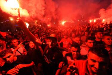 Algeria's fans celebrate and hold flares as they watch the FIFA 2014 World Cup football match Algeria vs South Korea in Algiers, on June 22, 2014. AFP PHOTO/FAROUK BATICHE