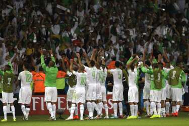 Algerian players reach out to their supporters  after the group H World Cup soccer match between South Korea and Algeria at the Estadio Beira-Rio in Porto Alegre, Brazil, Sunday, June 22, 2014. Algeria won the match 4-2.  (AP Photo/Fernando Vergara)