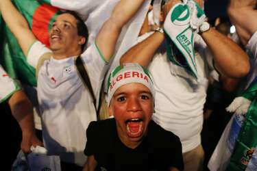 An Algeria young soccer fan celebrates his team's victory after a live broadcast of the group H World Cup match between Korea and Algeria, inside the FIFA Fan Fest area on Copacabana beach, in Rio de Janeiro, Brazil, Sunday, June 22, 2014. (AP Photo/Leo Correa)