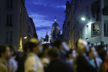 The Basilica of the Sacre Coeur is seen in the background as Algeria fans gather to watch the 2014 FIFA World Cup football match between Algeria and Russia in central Paris on June 26, 2014. AFP PHOTO / KENZO TRIBOUILLARD