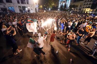 Algerian fans celebrate in Algiers on June 26, 2014 after Algeria eliminated Russia with a 1-1 draw in a FIFA 2014 World Cup Group H match.   AFP PHOTO/FAROUK BATICHE