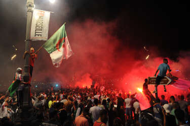 Algeria's football fans celebrate on the Canebiere in Marseille, southern France, on June 26, 2014 after the match Algeria vs Russia in a FIFA 2014 World Cup Group H match.  Algeria progressed to the last 16 of the World Cup for the first time in their history as Islam Slimani's second-half header was enough to earn them a 1-1 tie against Russia. AFP PHOTO / BORIS HORVAT