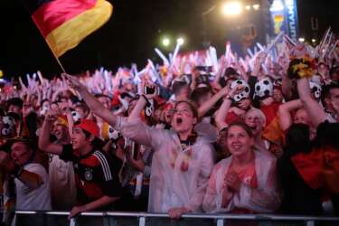 German soccer fans celebrate after their team scores at the Brazil World Cup semi final being played in Belo Horizonte, Brazil, between Germany and Brazil at a public viewing event called 'Fan Mile' in Berlin, Tuesday, July 8, 2014. (AP Photo/Markus Schreiber)