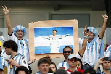 Argentina fan hold a picture of Lionel Messi as Christ the redeemer prior to the group F World Cup soccer match between Nigeria and Argentina at the Estadio Beira-Rio in Porto Alegre, Brazil, Wednesday, June 25, 2014. (AP Photo/Victor R. Caivano)