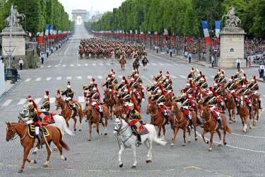 Republican Guards on horseback ride down the Champs-Elysees avenue during the annual Bastille Day military parade in Paris, on July 14, 2014.  AFP PHOTO / ALAIN JOCARD