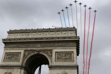 France's national colours trail above the Arc de Triomphe during the traditional Bastille Day parade on the Champs Elysees in Paris, July 14, 2014. The year 2014 marks the 100th anniversary of the start of the First World War.   REUTERS/Gonzalo Fuentes (FRANCE  - Tags: MILITARY ANNIVERSARY POLITICS)