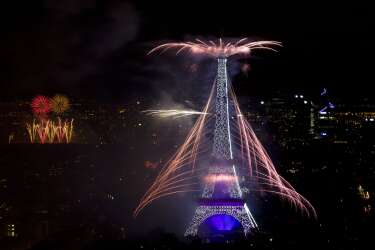 Fireworks burst around the Eiffel Tower in Paris on July 14, 2014 as part of France's annual Bastille Day celebrations.  AFP PHOTO / KENZO TRIBOUILLARD