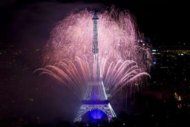 Fireworks burst around the Eiffel Tower in Paris on July 14, 2014 as part of France's annual Bastille Day celebrations.  AFP PHOTO / KENZO TRIBOUILLARD