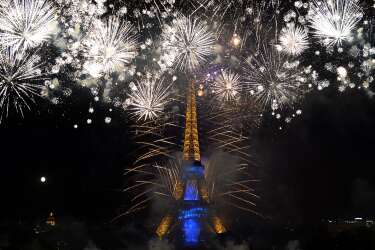 Fireworks burst around the Eiffel Tower in Paris on July 14, 2014 as part of France's annual Bastille Day celebrations.  AFP PHOTO / PIERRE ANDRIEU