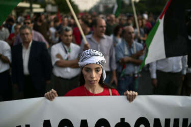 A protester holds a banner as she chants slogans against the Israeli air strikes on Gaza during a massive demonstration outside the Israeli embassy in Athens on July 17, 2014.   Israeli air strikes in Gaza killed four children on July 17, medics said, hours after a temporary humanitarian ceasefire ended.  Their deaths brought the toll in Gaza in a 10-day Israeli operation to stamp out militant rocket fire to 237, with at least 1,770 wounded. AFP PHOTO/ LOUISA GOULIAMAKI